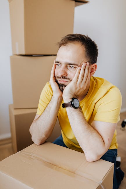Overwerkte medewerker die handmatig dozen vouwt